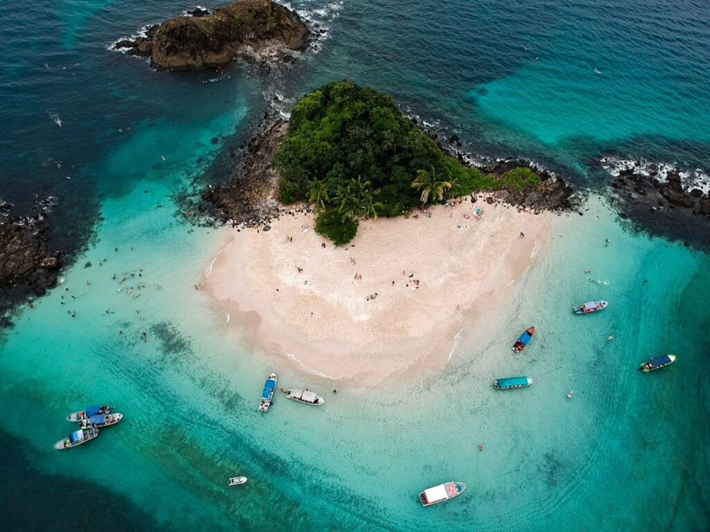 Eco-travel scene with boat and forested coastline in Coiba