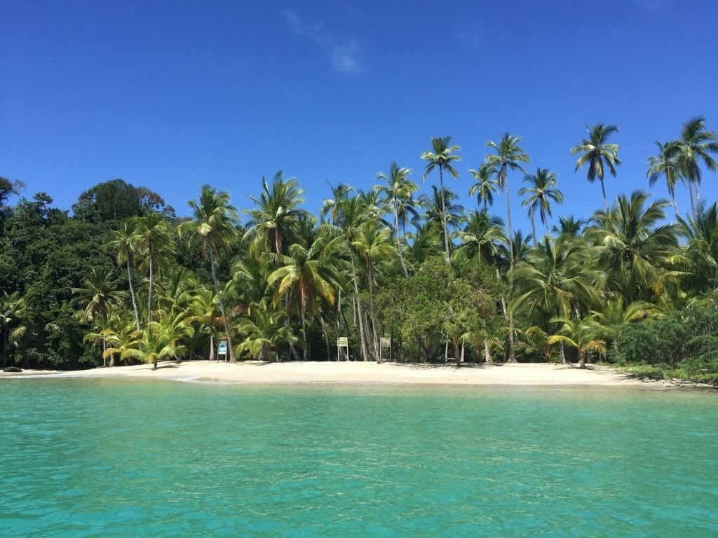 Travelers walking along quiet beach in Coiba area