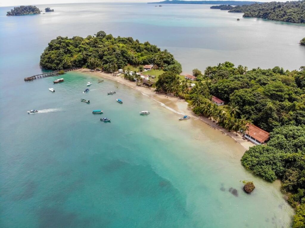 Boat moving along rugged coastline near Coiba